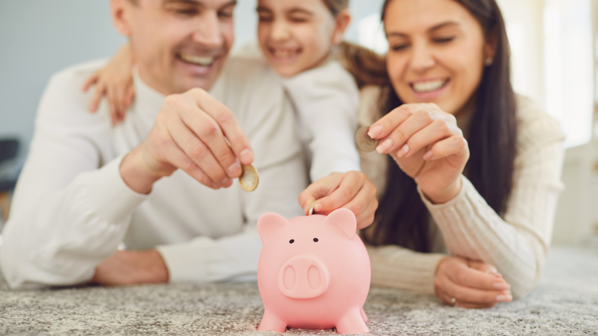 Parents and their daughter happily saving money by putting coins into a piggy bank, symbolizing financial literacy and savings thanks to solar incentives.