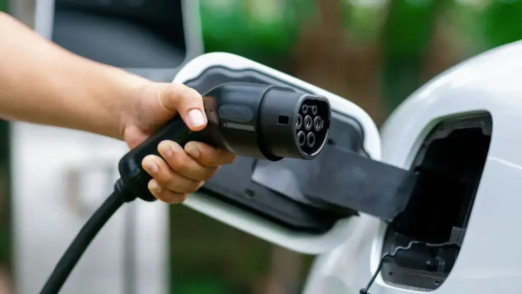 Home EV charger mounted on wall with vehicle plugged in