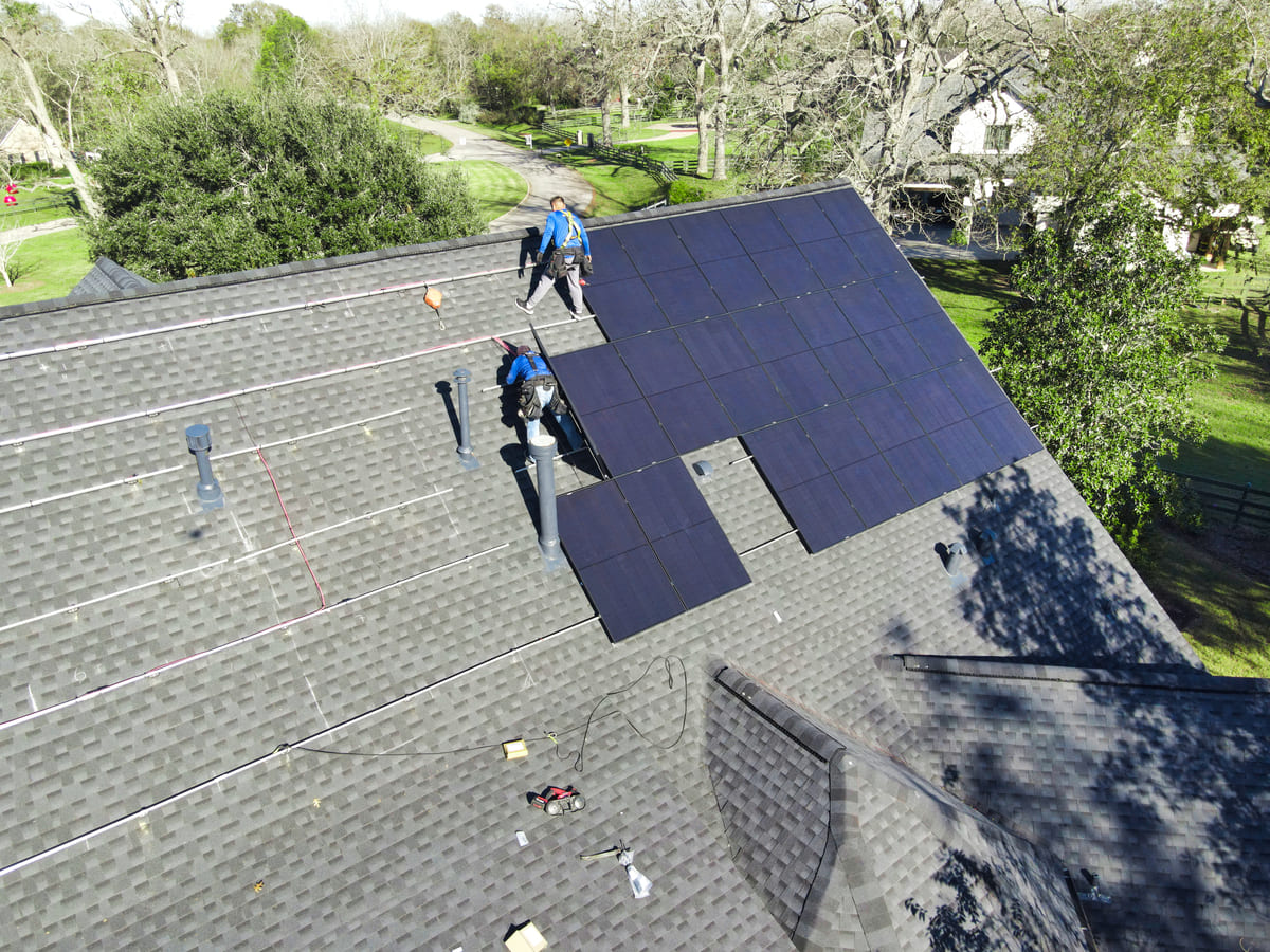 Solstice Solar team professionally installing solar panels and inverters on a residential roof.