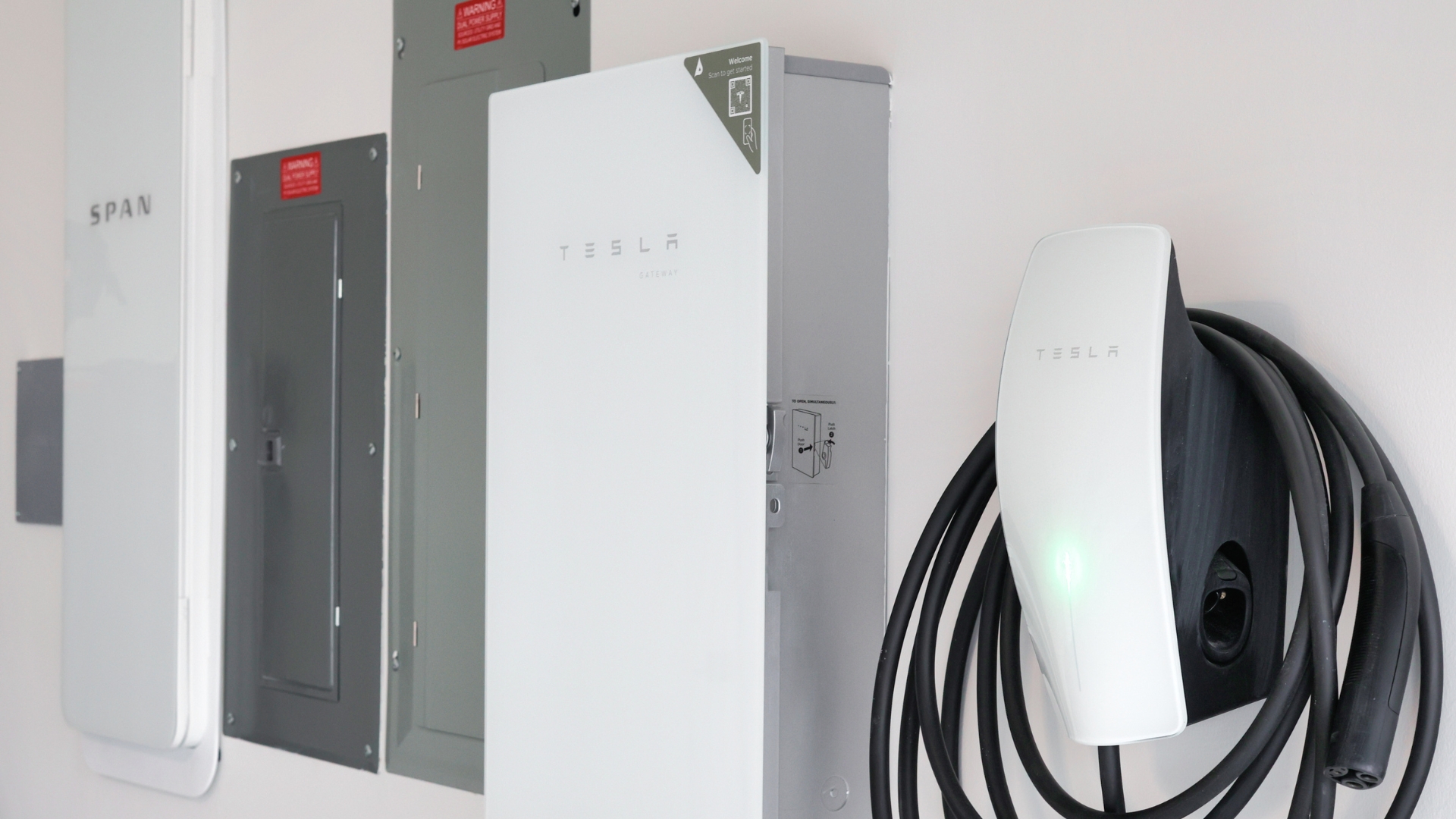 Image showing SPAN smart panel installed alongside Tesla Gateway 3 and Tesla EV Charger setup.