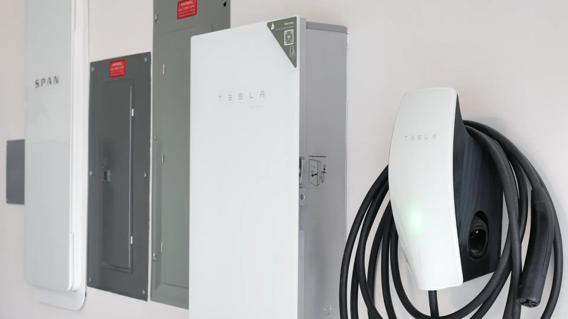 Image showing SPAN smart panel installed alongside Tesla Gateway 3 and Tesla EV Charger setup.